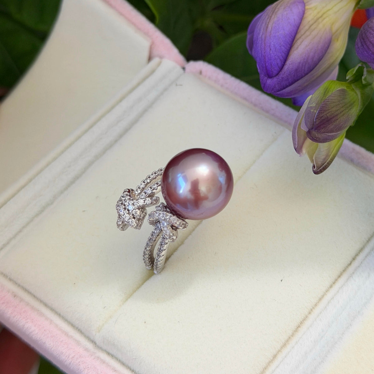 Blue halo pearl ring with sparkling bow-shaped accents.