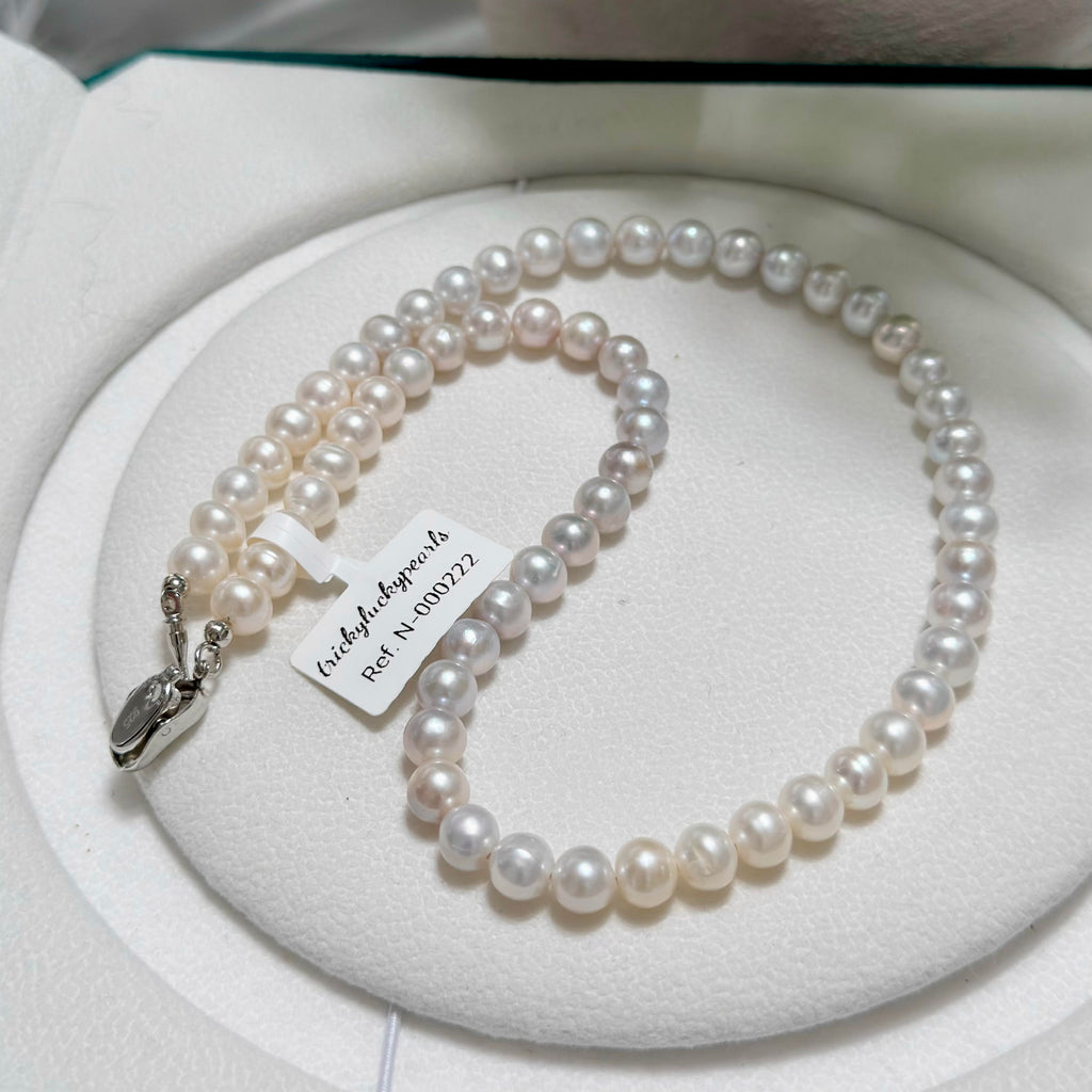 Undyed natural pearls arranged in a grey-to-white gradient.
