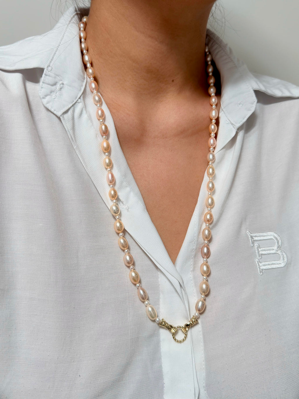 Model wearing a long golden-orange freshwater pearl necklace.