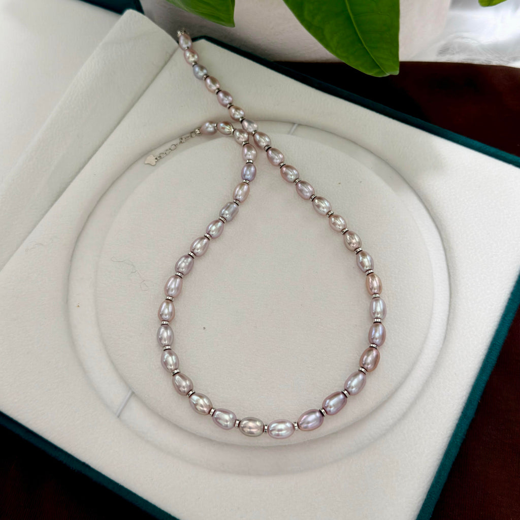 Purple freshwater pearl strand accented with sterling silver spacer details.
