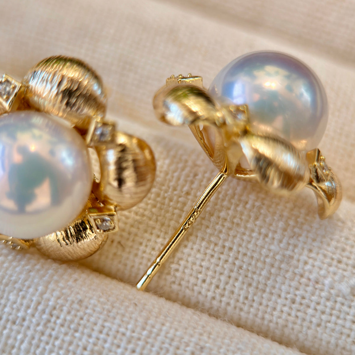 Mirror-lustre white freshwater pearl earrings in floral settings.