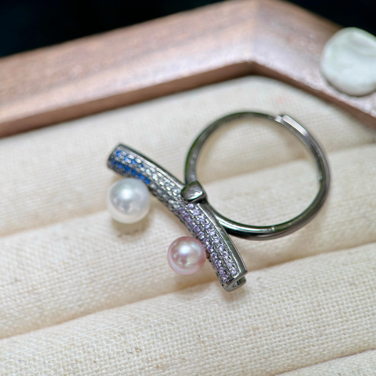 Purple-blue freshwater pearl paired with a white pearl on silver ring.