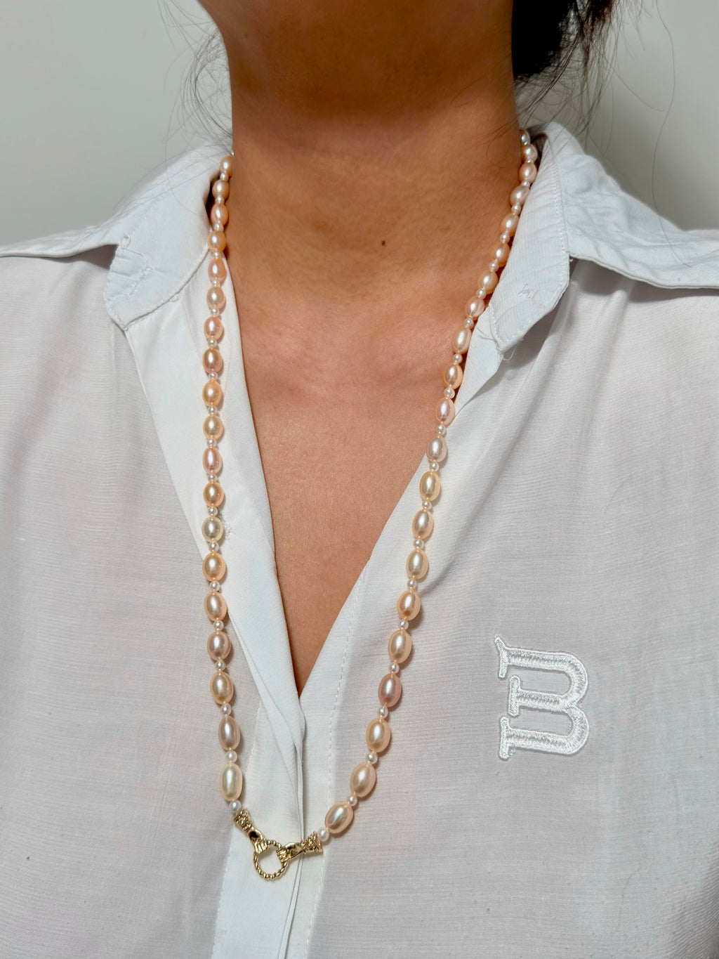Golden-orange pearl necklace styled for layered wear.