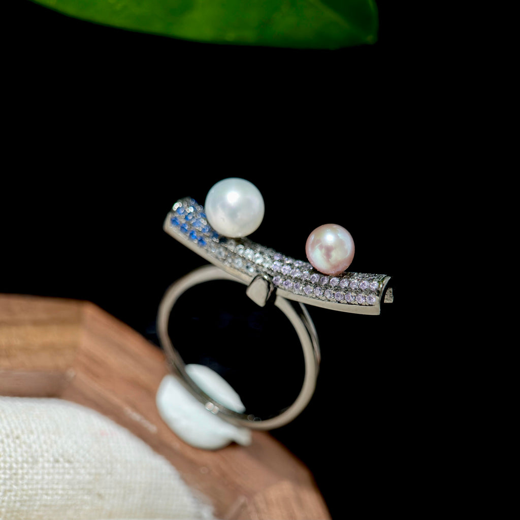 Adjustable sterling silver kinetic pearl ring with movable balance design.