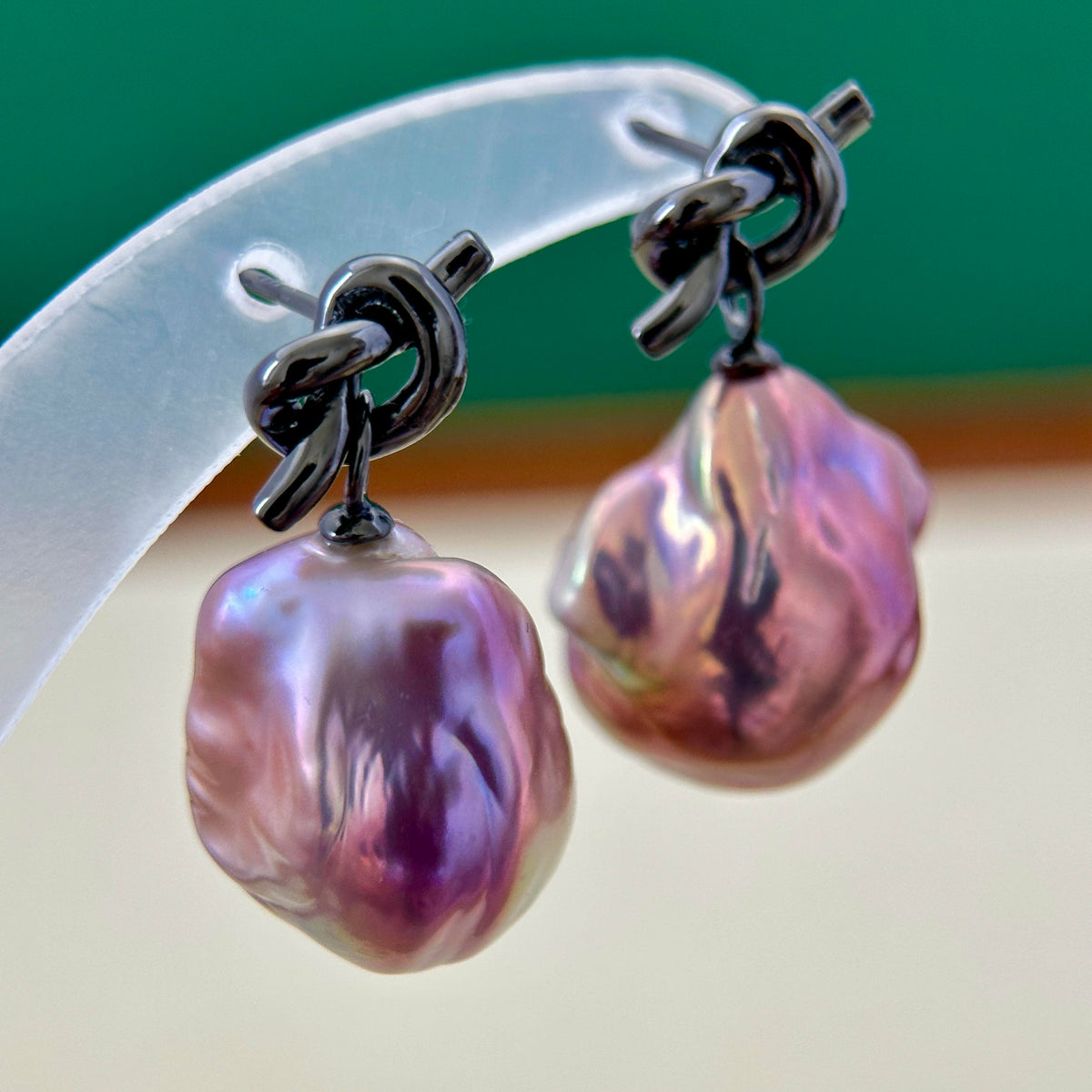 
Multicolor pearl drop earrings showing purple red and green iridescent tones.