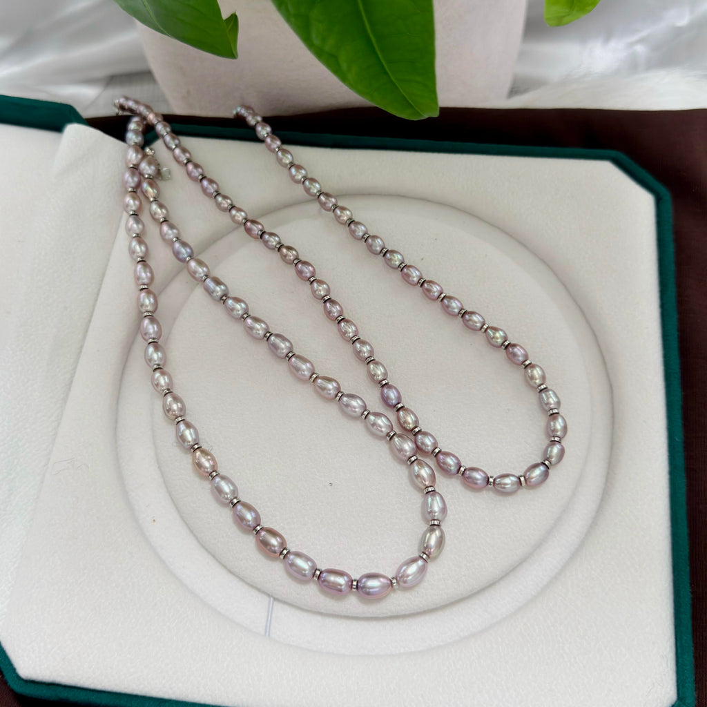 Modern freshwater pearl necklace with oval purple pearls and multicolor iridescent halos.
