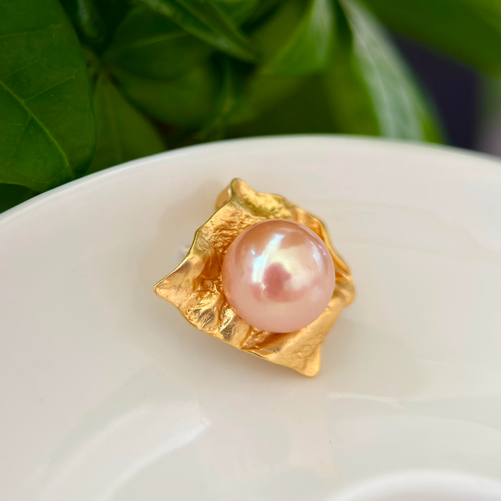 Artistic golden pearl pendant styled as modern evening jewelry.
