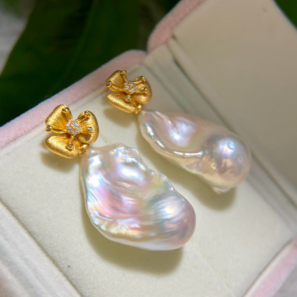 28 mm white baroque pearl earrings with pink and blue iridescent halos.
