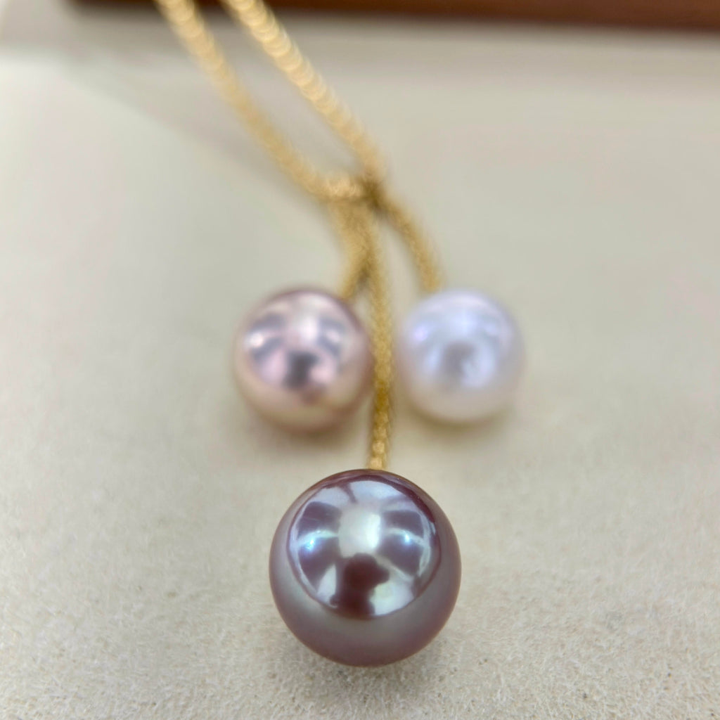 Deep purple pearl with blue halo featured on a modern pearl necklace.