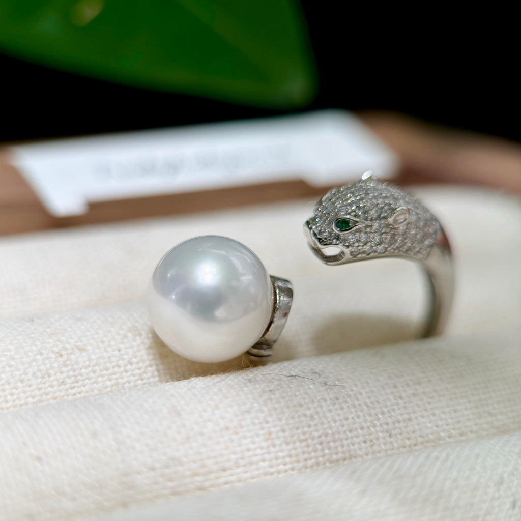 11.4 mm white freshwater pearl panther ring with green eyes.