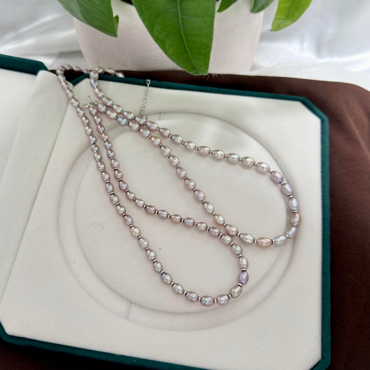 Purple oval freshwater pearl necklace showing green, gold, blue and red reflections.
