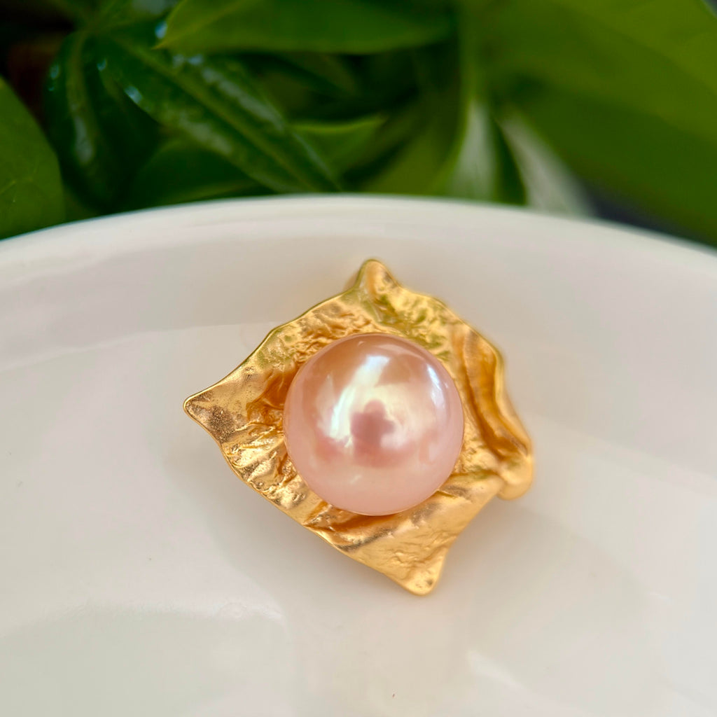 Close-up of an 11.8 mm golden freshwater pearl in a sculptural silver setting.