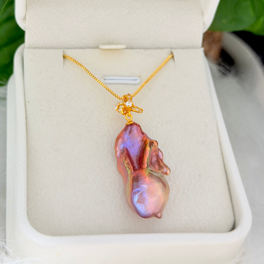Close-up of multicolor baroque freshwater pearl pendant with sculptural iris flower in sterling silver.
