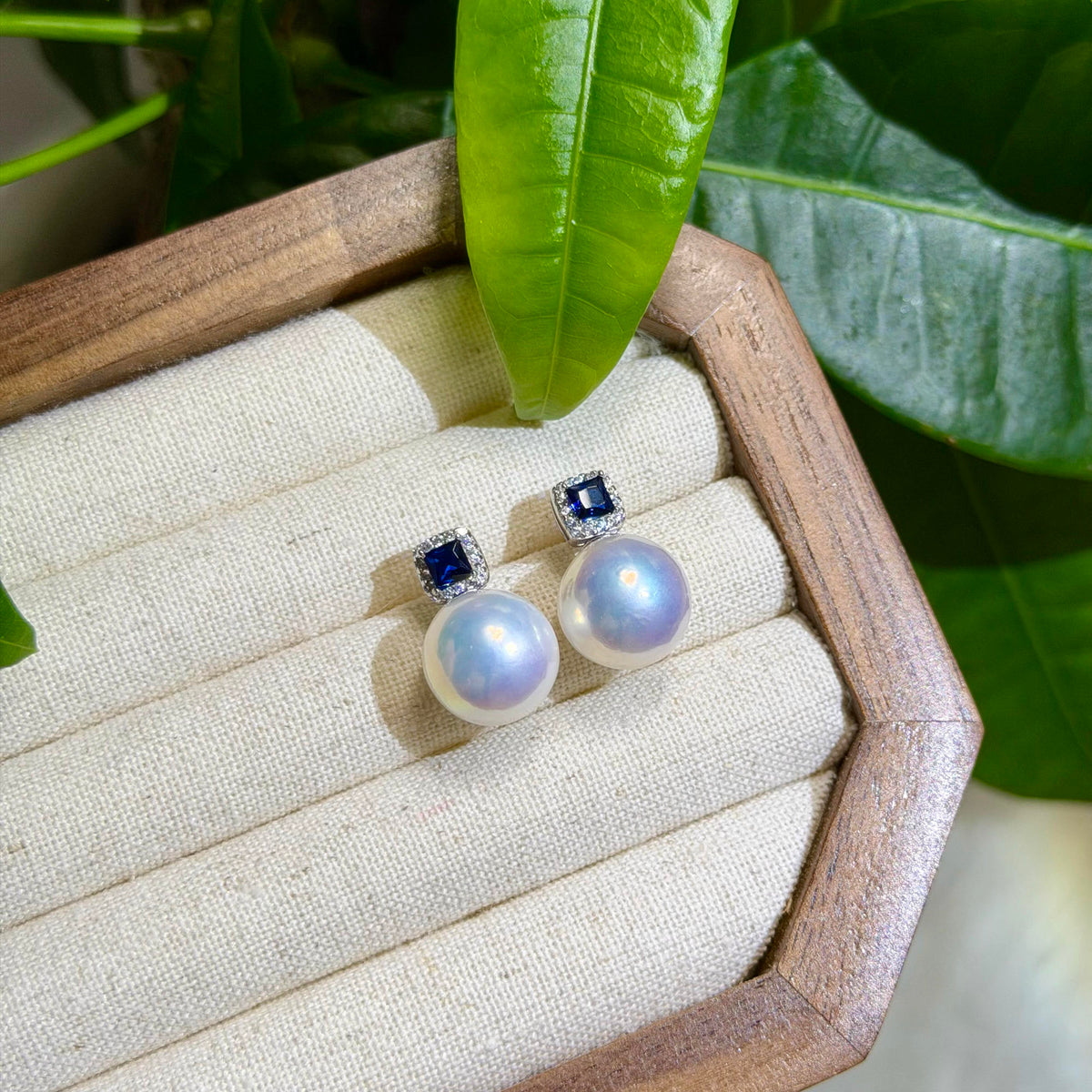 Statement pearl earrings featuring deep royal blue square stones.