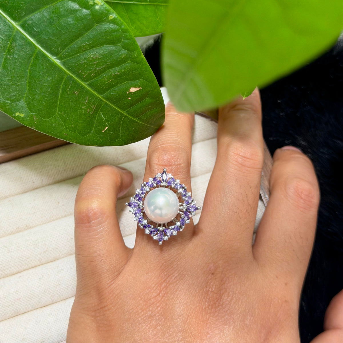 Purple marquise zirconia surrounding a white freshwater pearl.