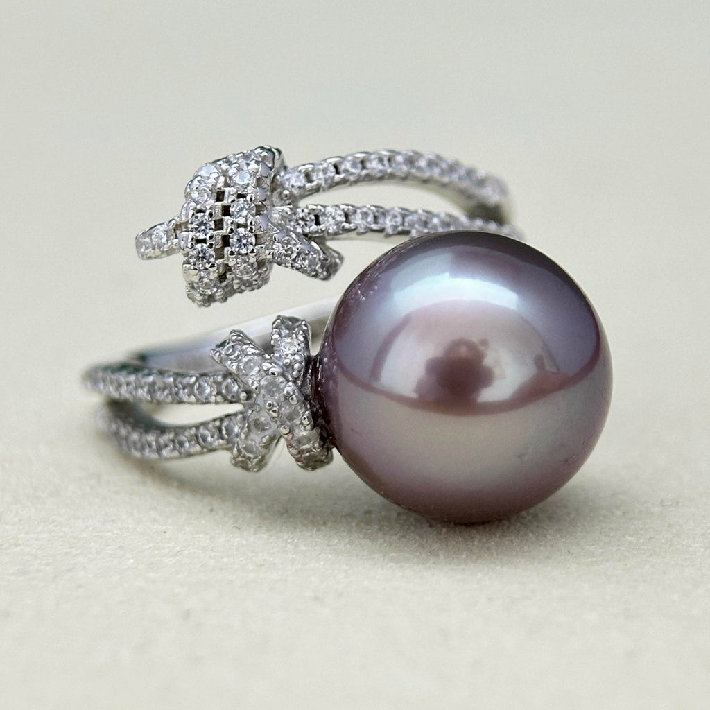 Blue halo pearl ring with sparkling bow-shaped accents.