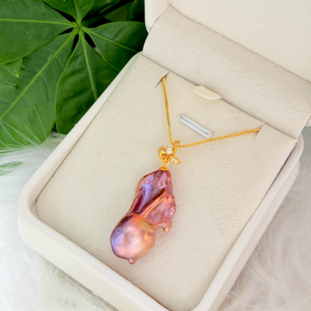 Detailed product view of multicolor baroque freshwater pearl pendant with sculptural iris flower in sterling silver.
