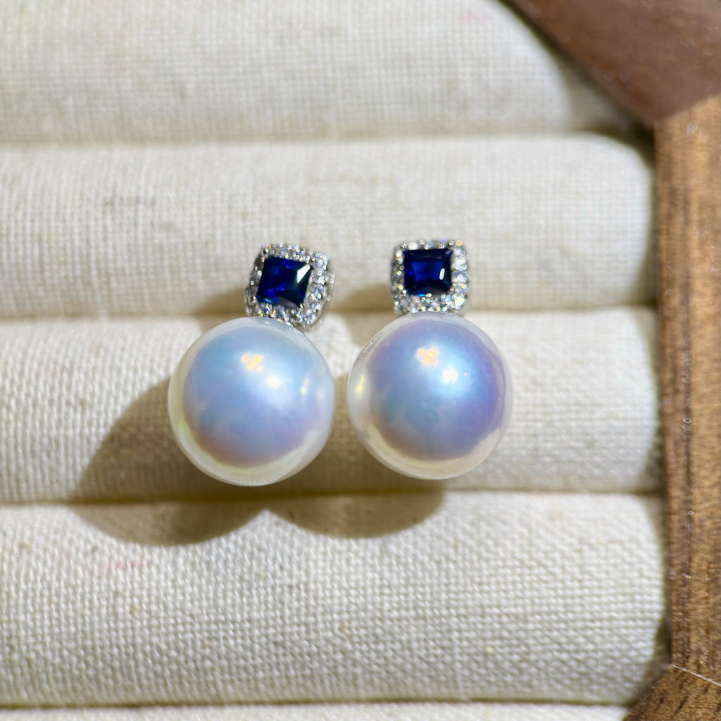 White pearl drop earrings with sparkling royal blue centerpiece.
