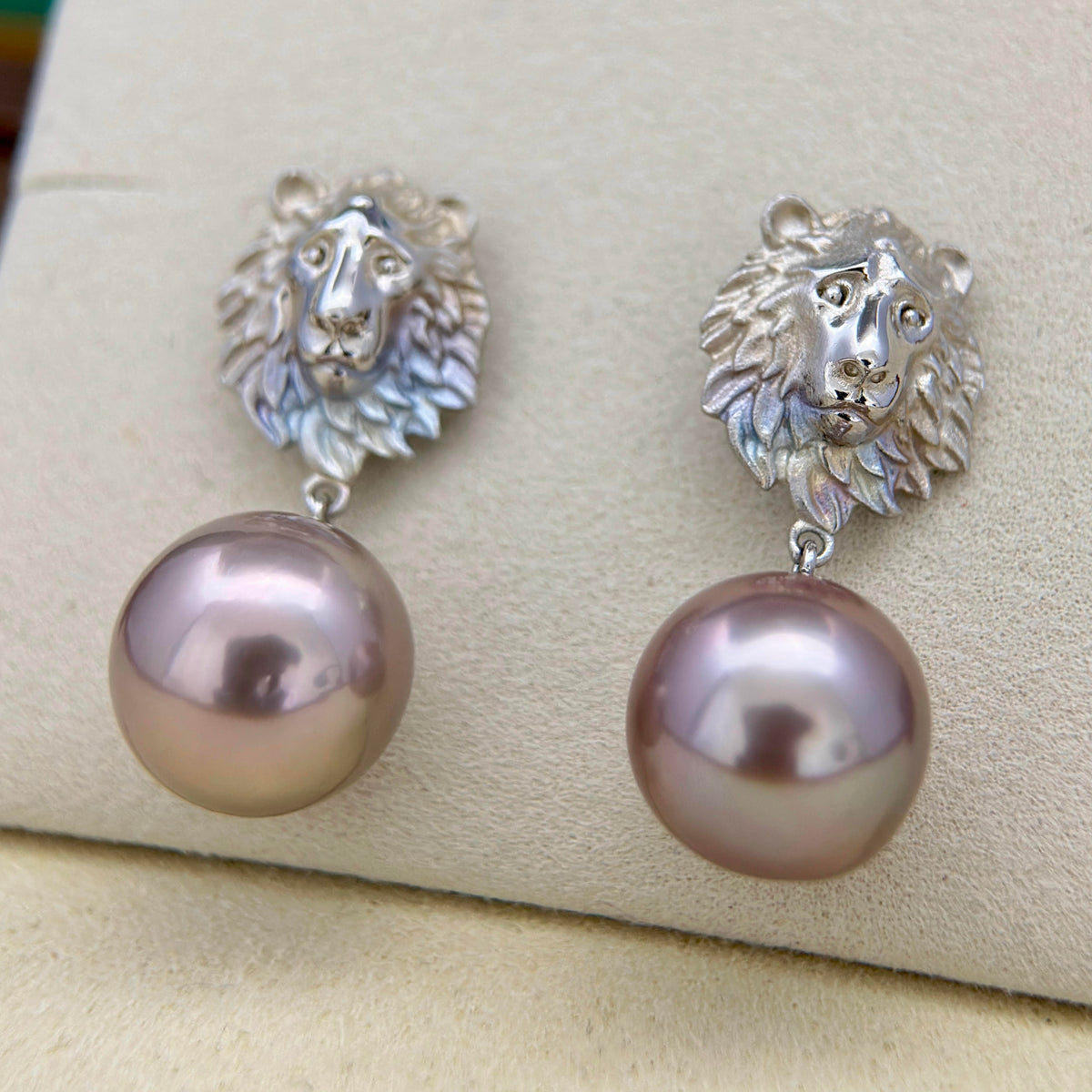Dark pearl earrings showing subtle reddish-purple reflections.