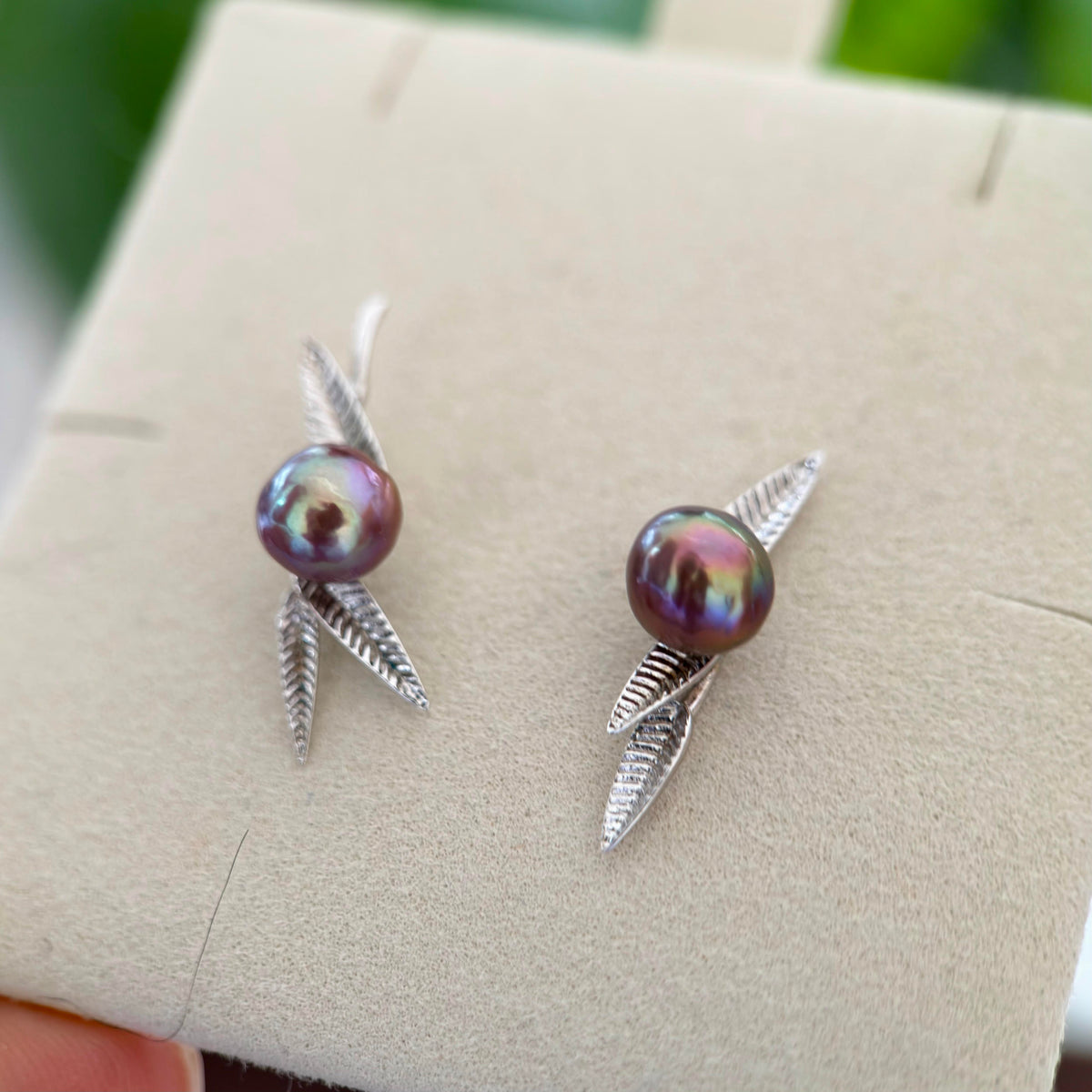 Artistic bamboo leaf earrings featuring 8 mm purple baroque freshwater pearls.