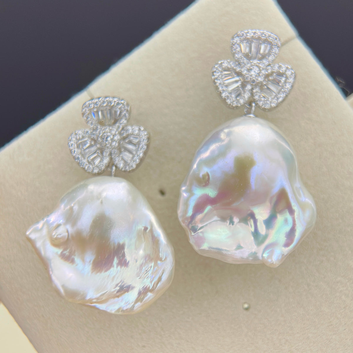 Lucky charm earrings featuring large white baroque freshwater pearl drops.
