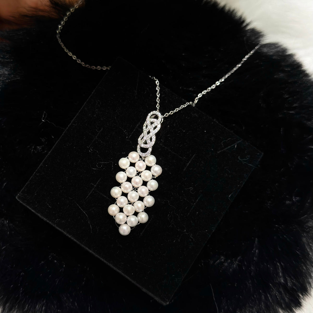 Woven pearl pendant necklace with luminous 4.5 mm white freshwater pearls.