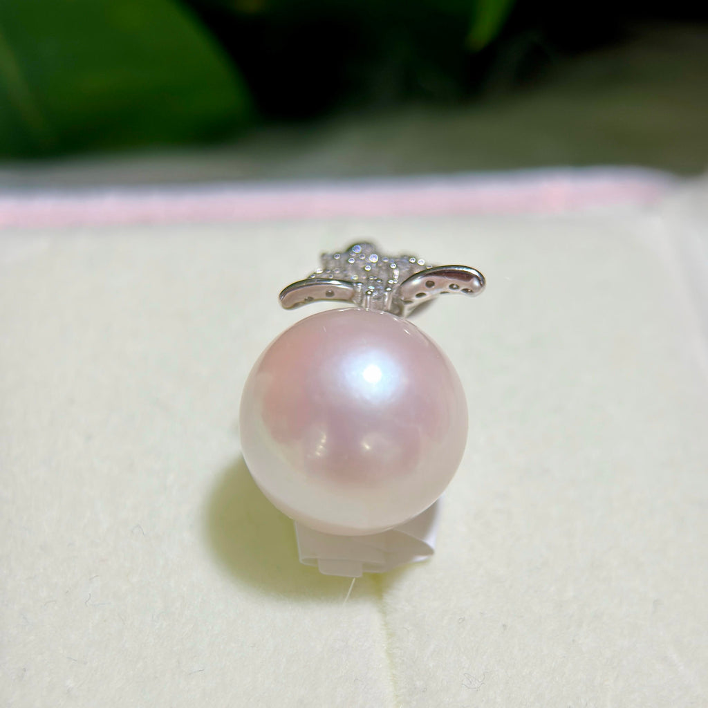 Close-up of a large white freshwater pearl with soft pink iridescence.