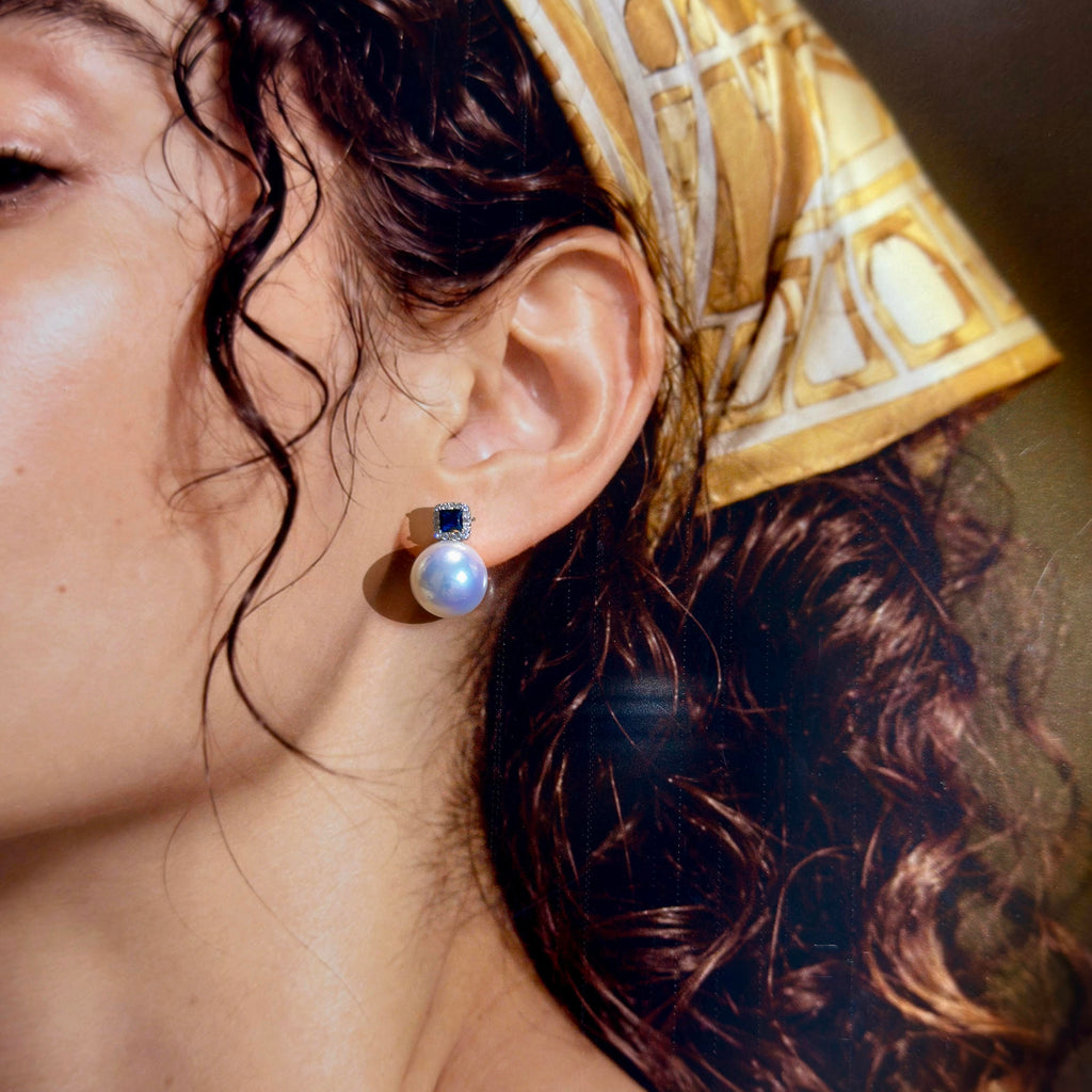 Bridal-style pearl earrings with royal blue and sparkling details.
