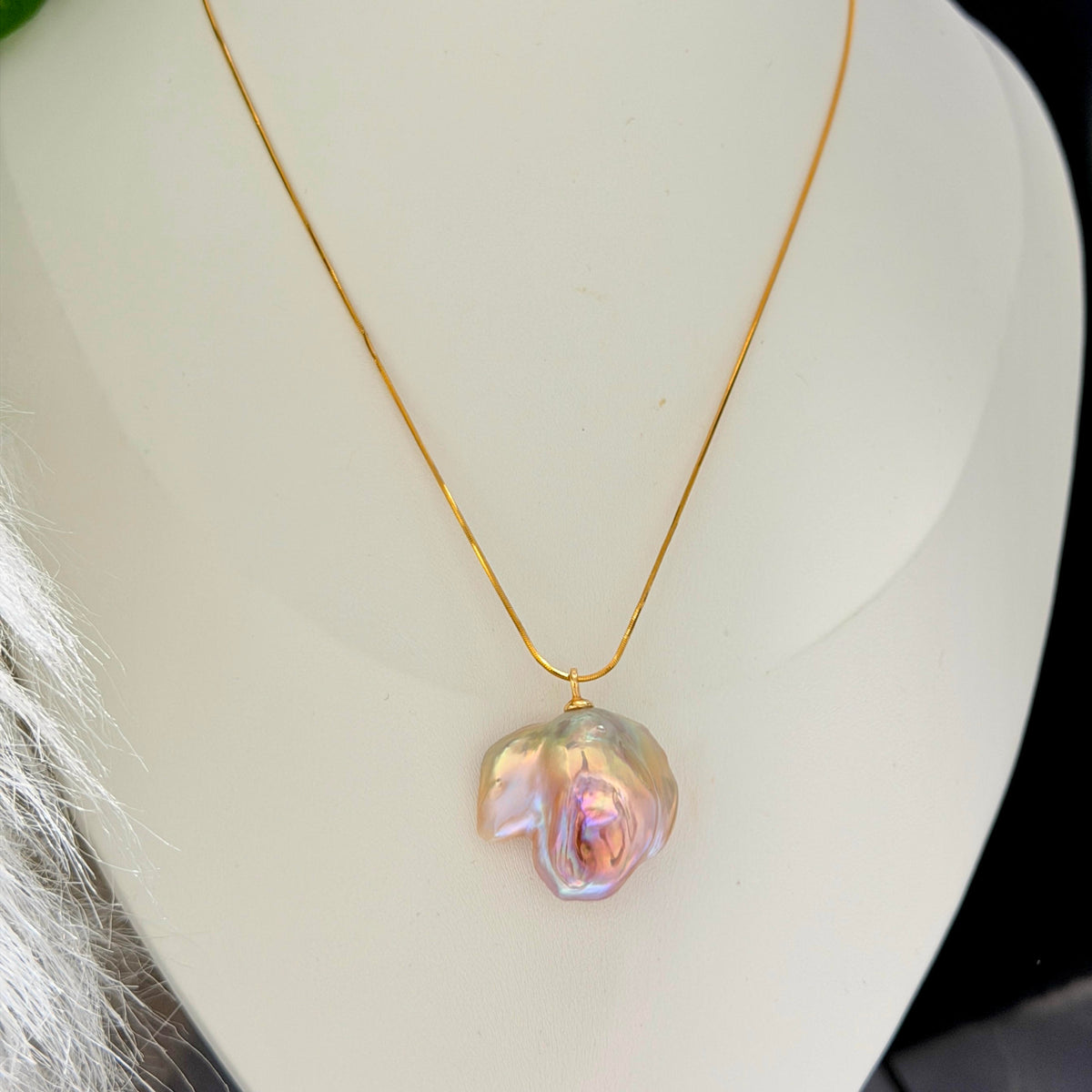 Close-up of lotus-inspired multicolor baroque freshwater pearl pendant on sterling silver snake chain.
