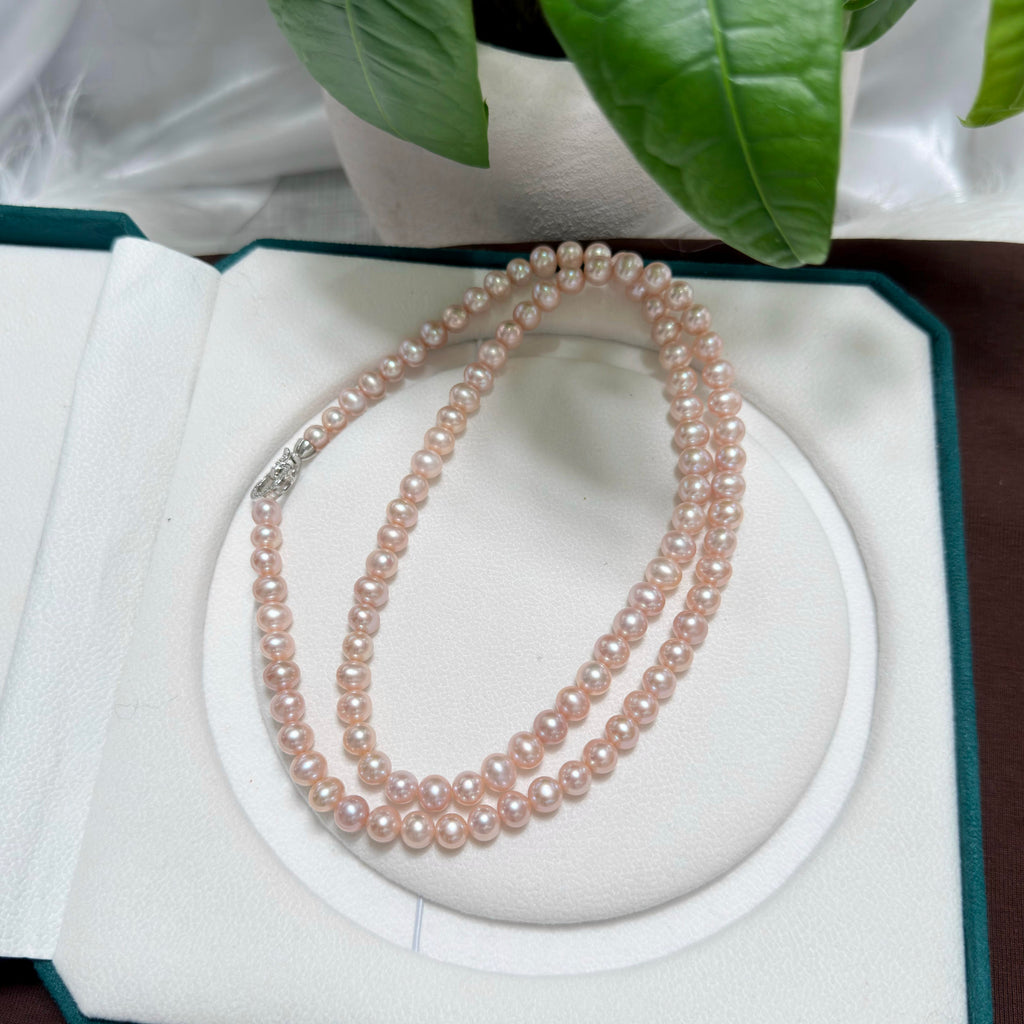 Close-up of luminous light pink and soft purple freshwater pearls with bright lustre.