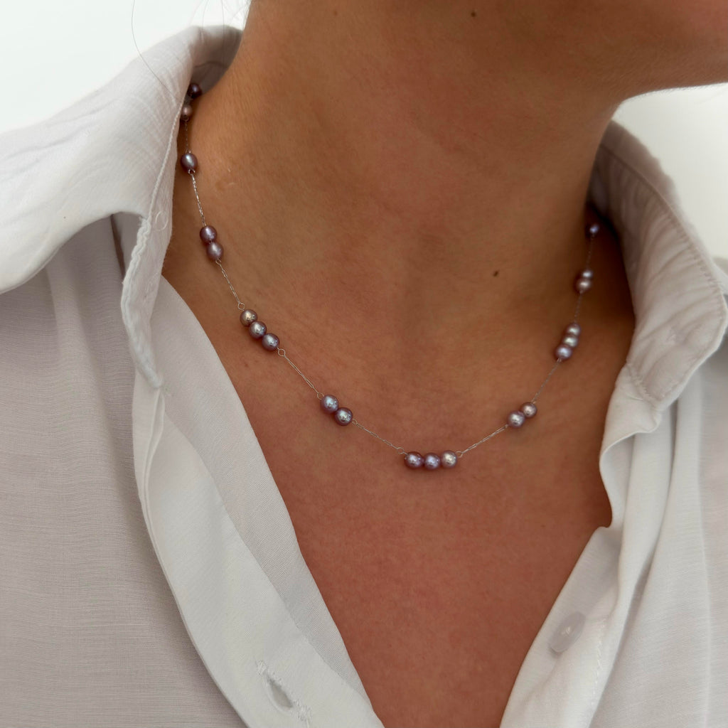 Purple freshwater pearl necklace displaying soft blue and green iridescent halos.