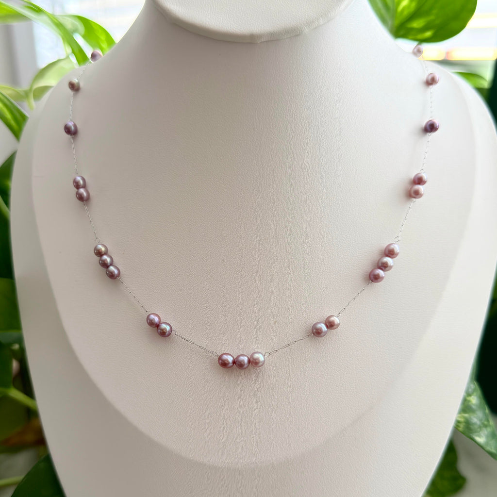 Purple freshwater pearls with a soft blue halo under changing light.