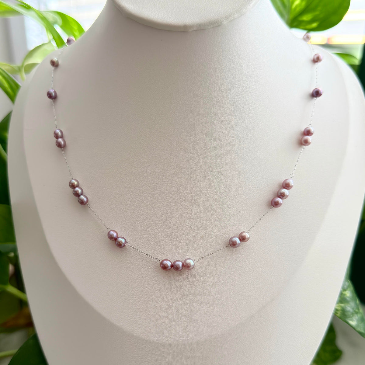 Purple freshwater pearls with a soft blue halo under changing light.