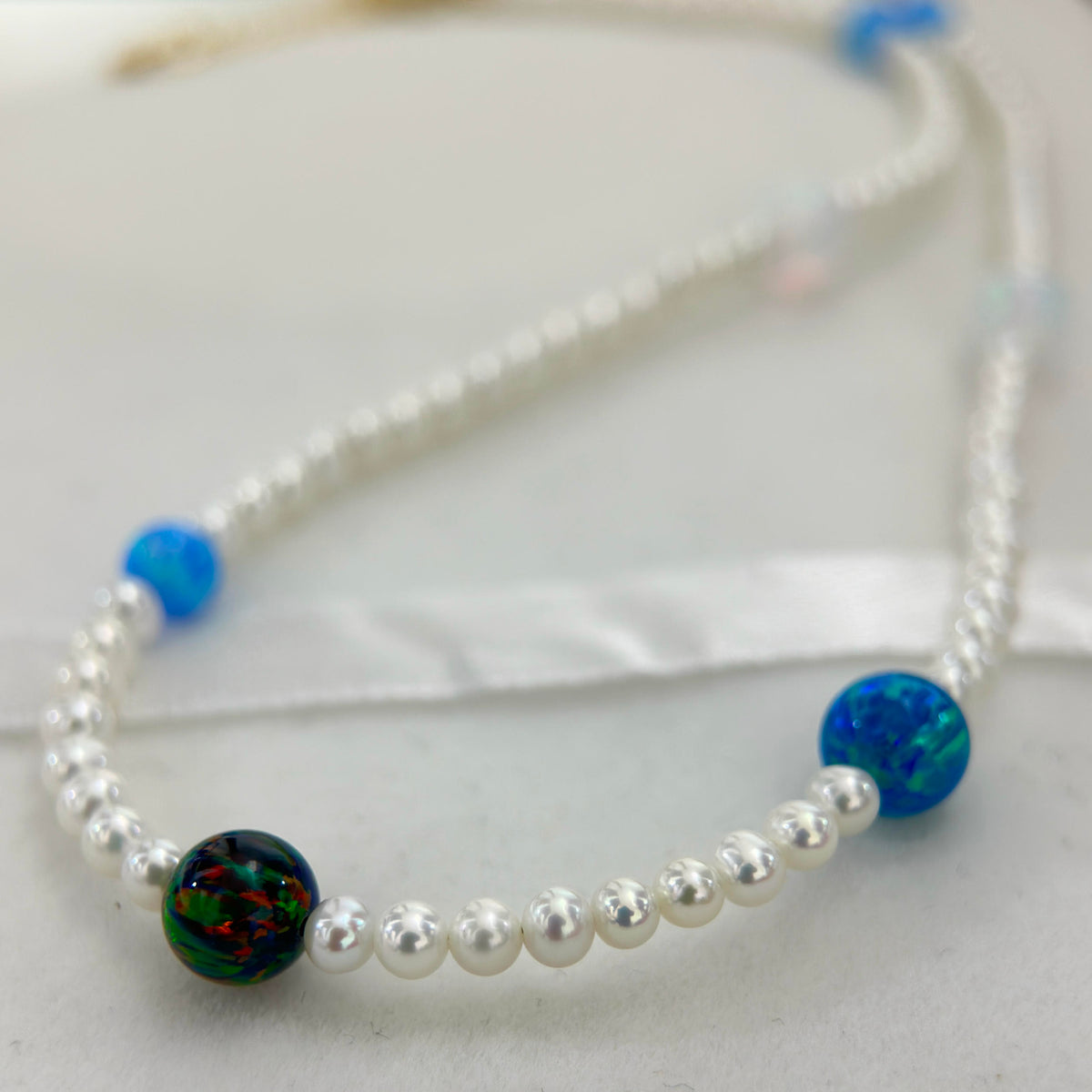 Cosmic pearl necklace featuring blue, water and iron opal accents.