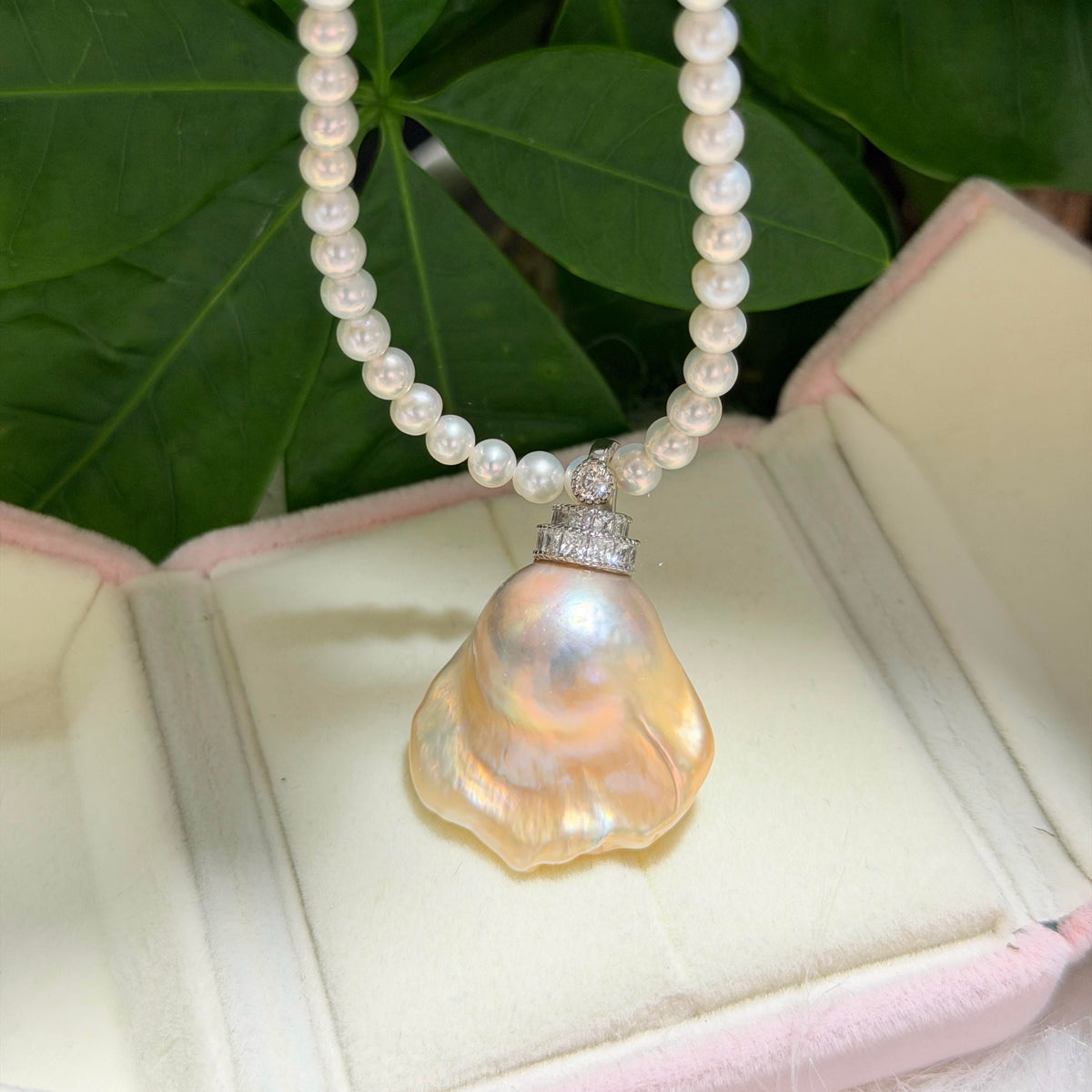 Detailed product view of golden-blue baroque freshwater pearl pendant with light golden halo and universal sterling silver bail.