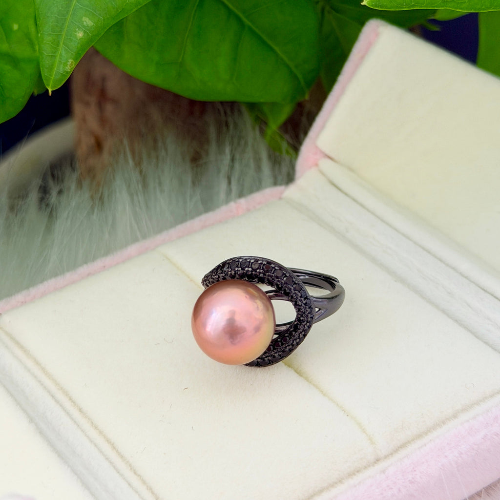 Golden-green halo pearl ring with black sparkling accents.