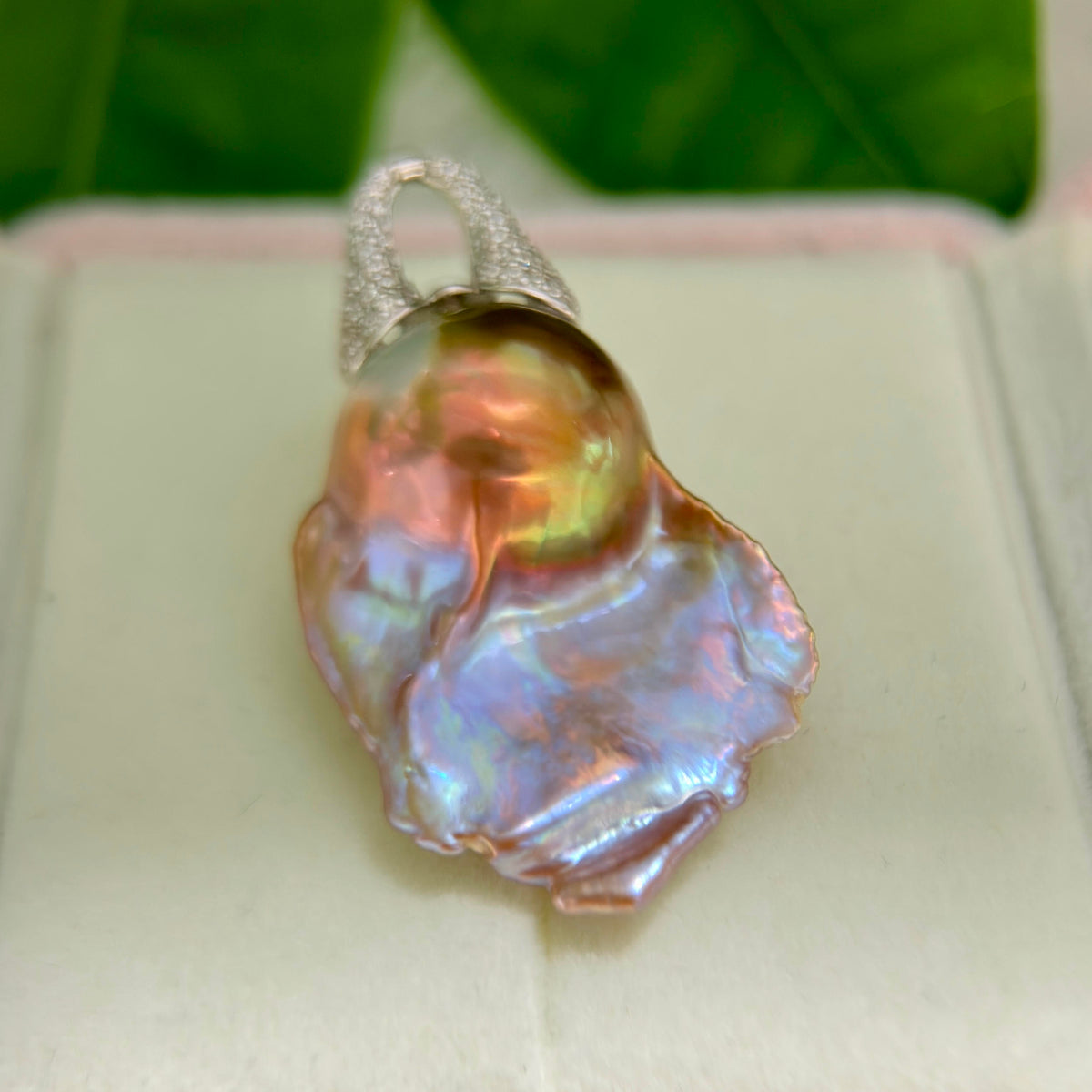 Baroque pearl pendant displaying blue purple and green iridescent halos.