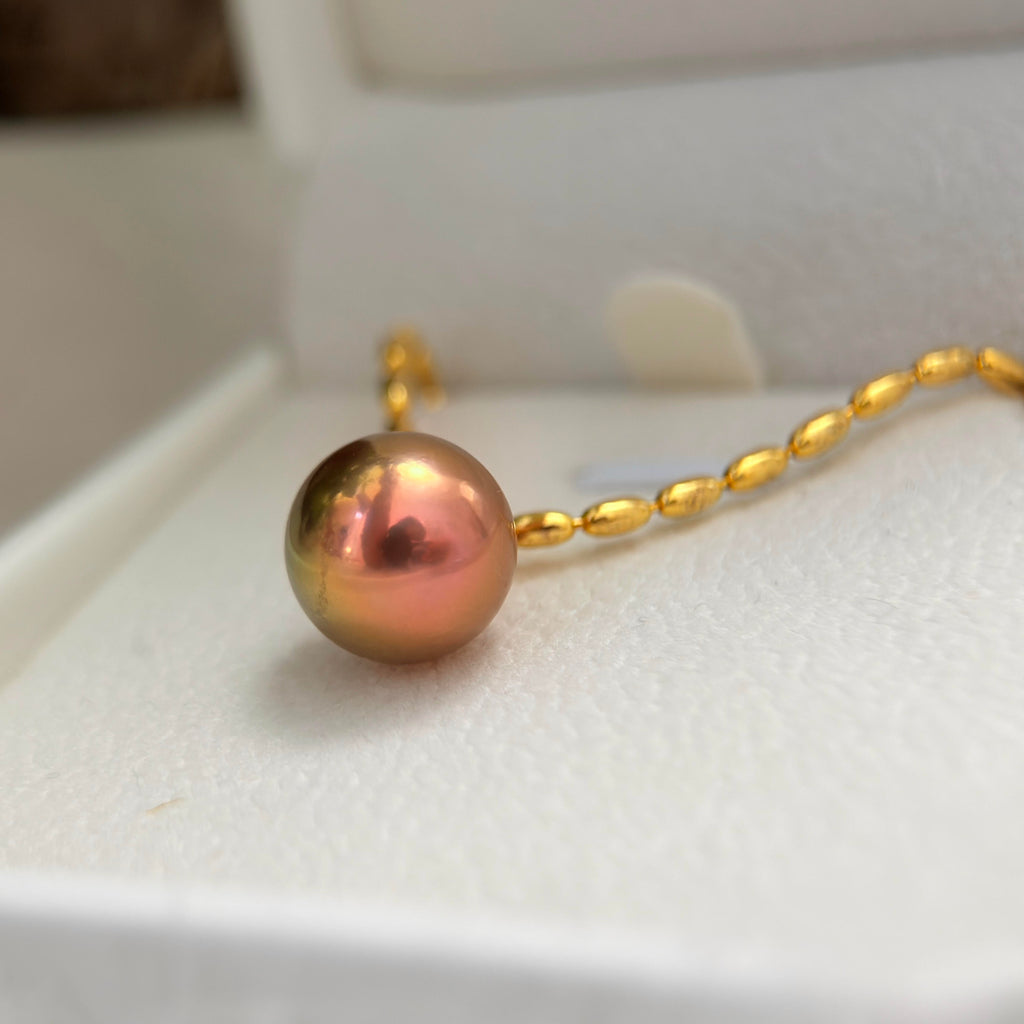 Close-up of a 12 mm natural freshwater pearl with shifting iridescent tones.