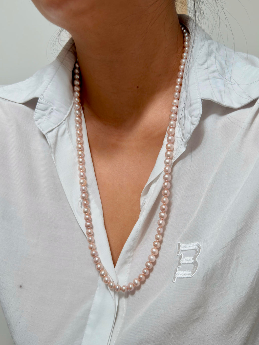 Romantic long freshwater pearl necklace with soft pink and purple tones.