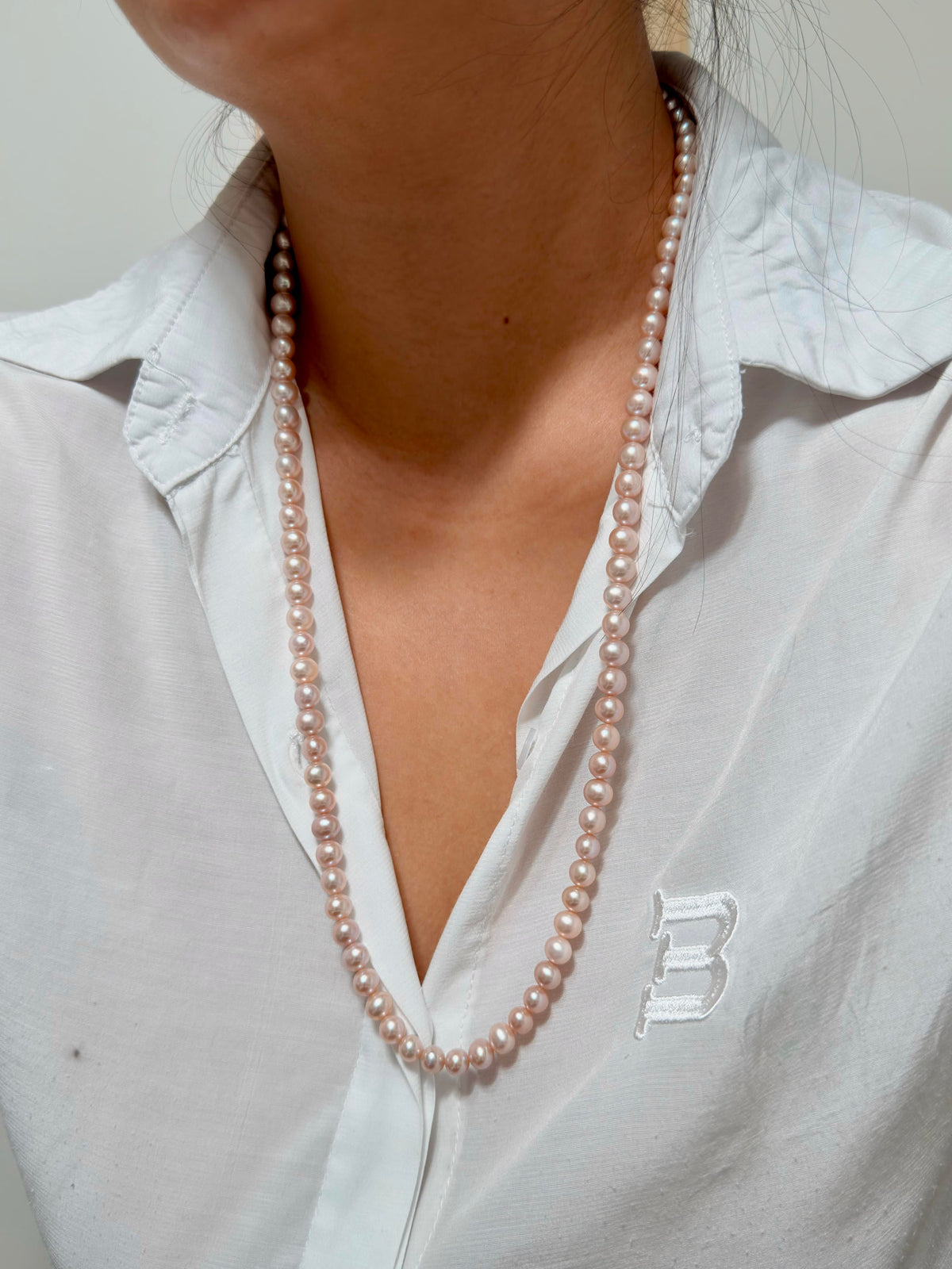 Romantic long freshwater pearl necklace with soft pink and purple tones.