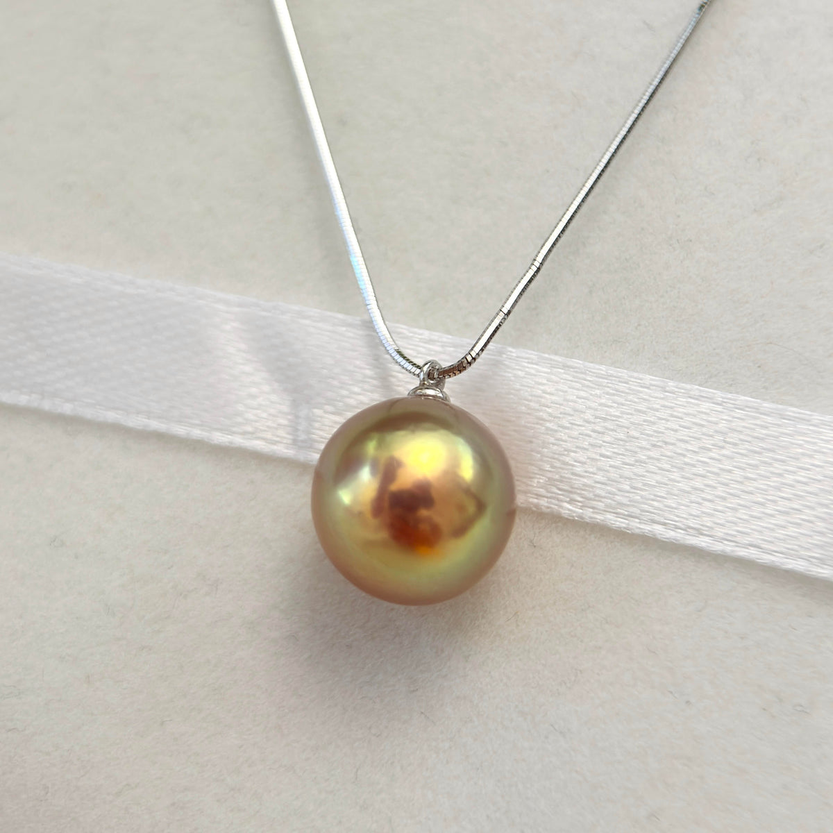 Green, gold and purple halo pearl necklace styled for an elegant dinner look.