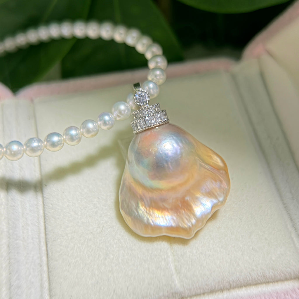 Close-up of golden-blue baroque freshwater pearl pendant with light golden halo and universal sterling silver bail.