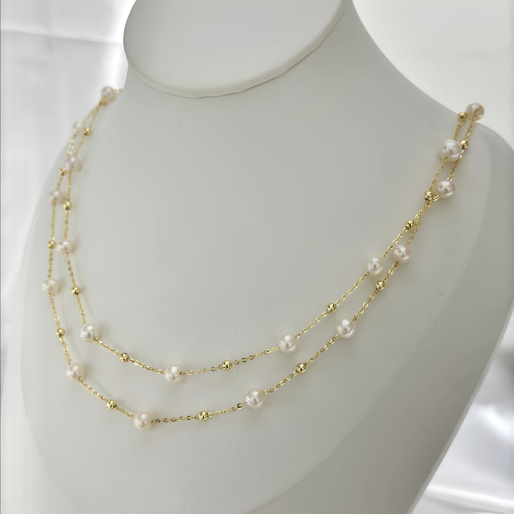 White pearl necklace doubled into an elegant layered look.