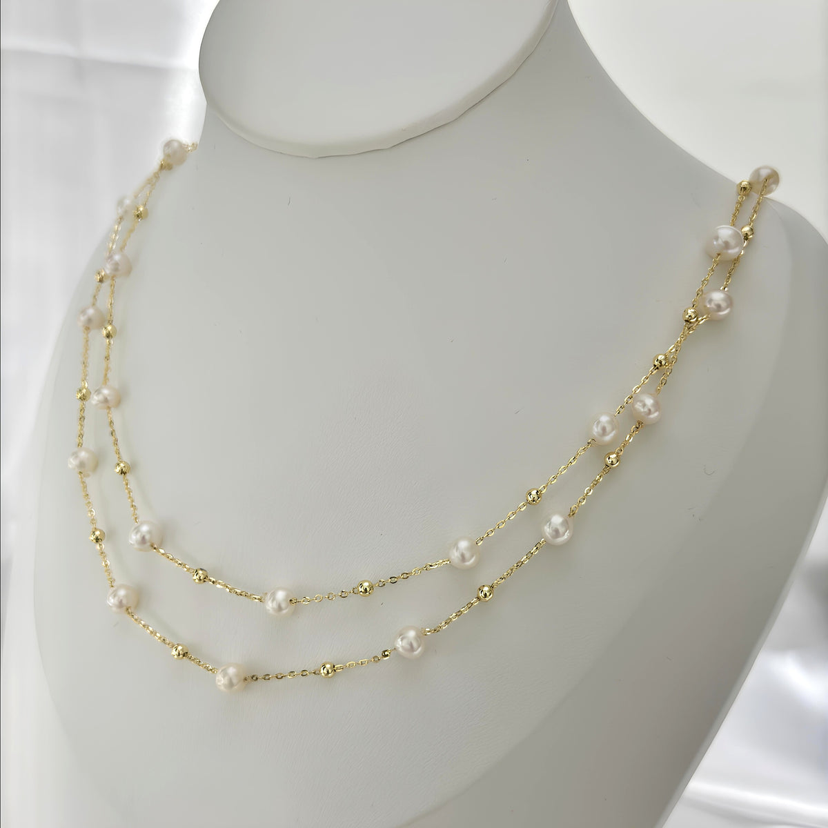 White pearl necklace doubled into an elegant layered look.