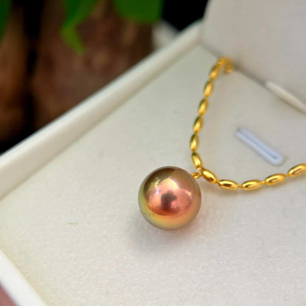 Large freshwater pearl displaying vivid green, gold and brown iridescence.
