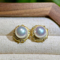 Mirror-lustre white pearl studs with vintage gold setting.