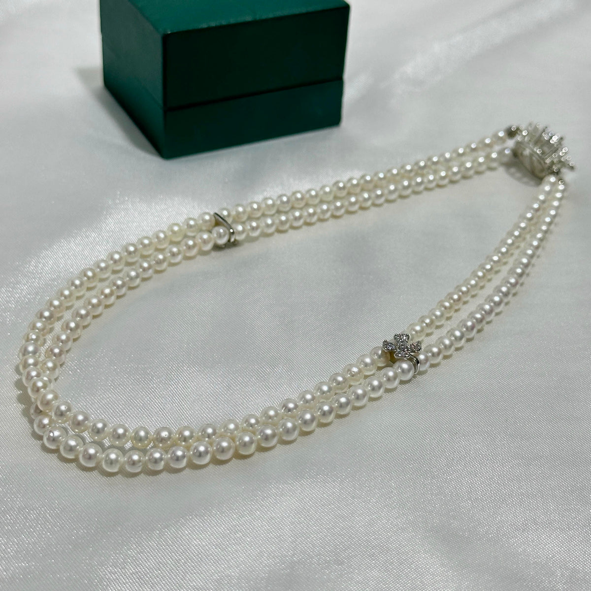 Double-layer white pearl necklace accented with sparkling cubic zirconia flowers.