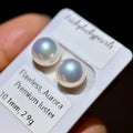 Two round iridescent freshwater pearls on a white display card labeled 'Flawless, Aurora Premium luster 10.1mm, 2.