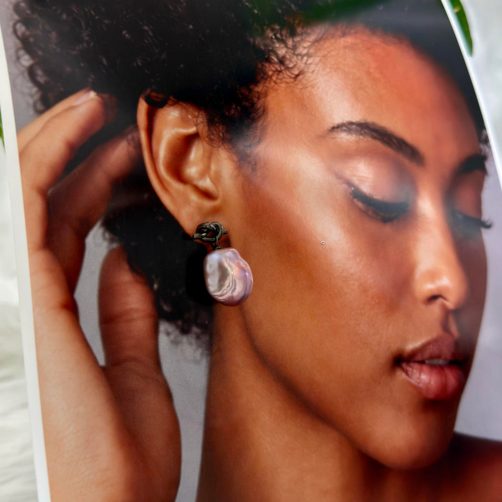 Model wearing black knot pearl earrings.