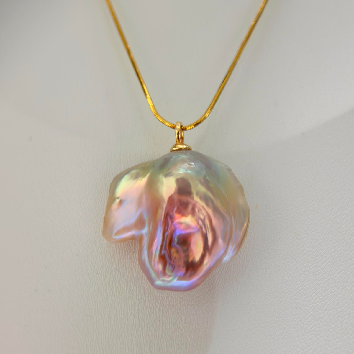Detailed product view of lotus-inspired multicolor baroque freshwater pearl pendant on sterling silver snake chain.
